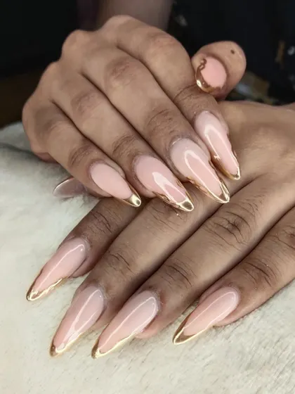 Sometimes, elegance is all you need. These long, stiletto-shaped extensions feature a clean nude base with a delicate gold chrome tip. It's a timeless and sophisticated look that we perfect for our clients.