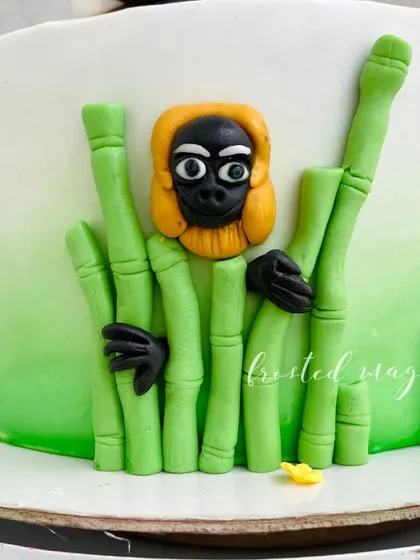 The expressive face of the Monkey figurine, adding personality to the overall cake design.