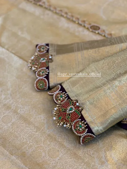 The sleeves feature cuff-style embroidery with peacock and floral motifs in kemp stones.