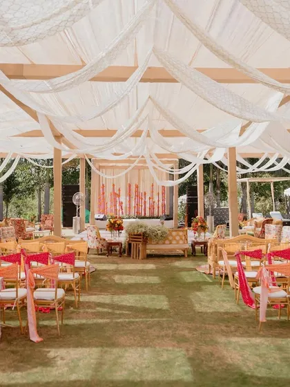 A wide view of the 'Rajasthani Folklore' Mehendi setup, showing the draped ceilings and various seating areas.