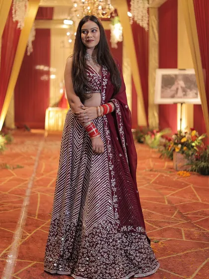 A beautiful shot of the client in her maroon chevron lehenga, ready for the celebration.