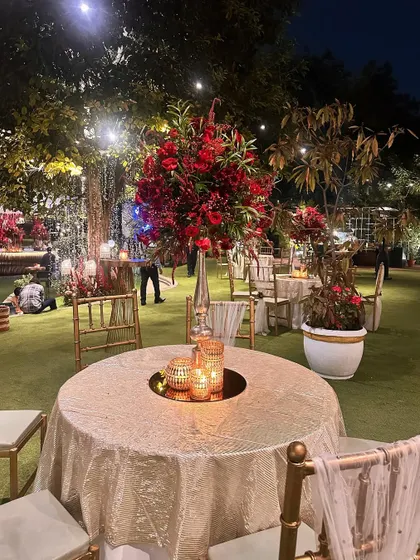 An elegant table setup with a tall red floral arrangement, part of a cohesive and luxurious event design.