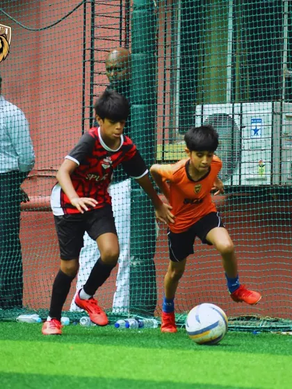 Two players battling for the ball in a competitive match against Spurs Madrid. These games test our skills against strong opposition.