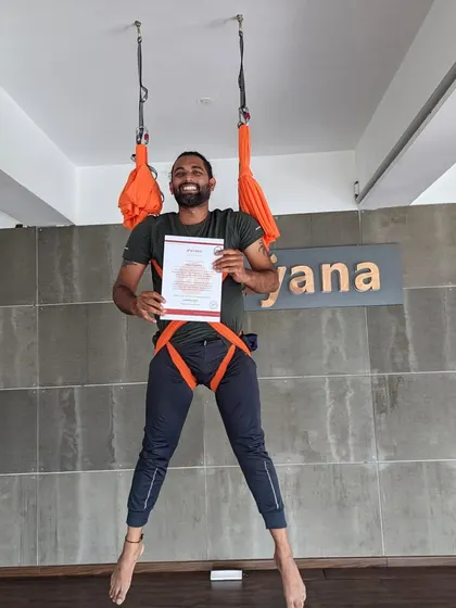 This graduate is all smiles after successfully finishing the intensive aerial yoga teacher training.