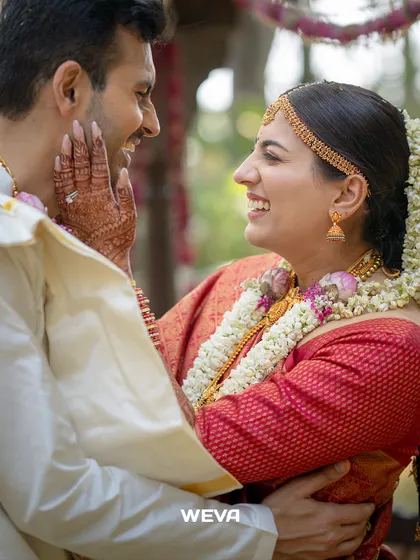 In this candid moment, you can see how the drape allows for natural movement and comfort. The bride's red silk wedding saree is draped to perfection, staying in place even during the most emotional and happy interactions.