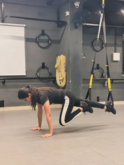 A TRX-assisted mountain climber, a challenging exercise that targets the core, shoulders, and legs all at once.