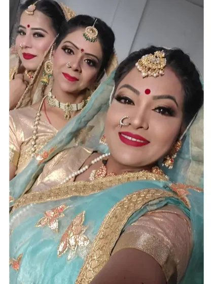 A closer look at the traditional makeup for a cultural event. The look features classic red lips, defined eyes, and traditional bindis to complement the performers' attire.