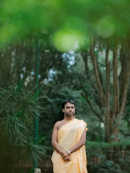 A portrait of the groom during the Kashi Yatra ritual, a significant part of many South Indian weddings, captured in a natural, outdoor setting.