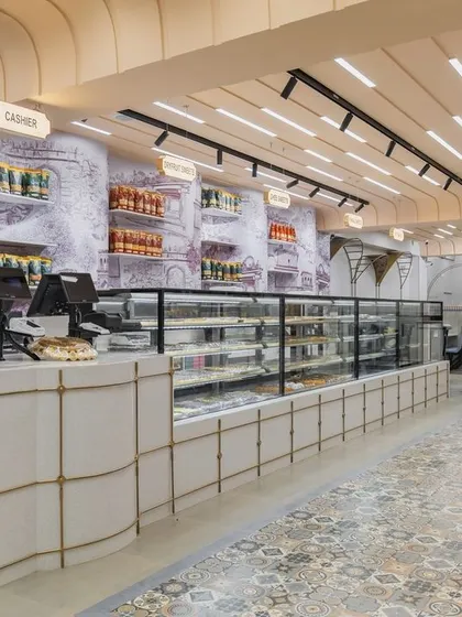 The main counter at Sangam Sweets, where a rich history of Indian architecture is reinterpreted. The design uses elements like columns, arches, and geometric patterns to create a modern space with deep cultural roots.