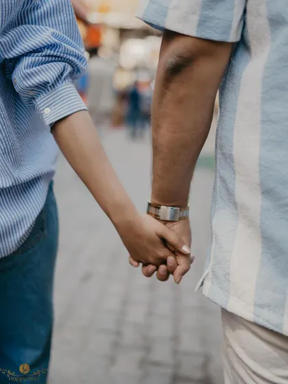 A close-up detail shot of a couple holding hands while walking through the city. It's a simple, symbolic gesture of their partnership, captured with an eye for storytelling details.