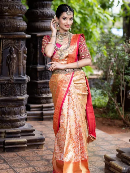 A full-length shot of the pink and gold silk saree, showing its graceful drape and rich texture. Perfect for a bride who wants a classic and regal look.