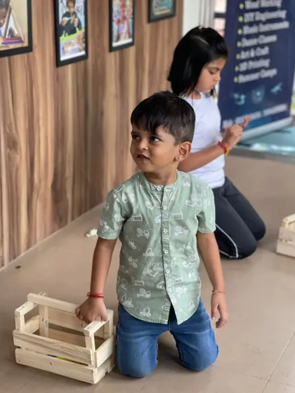 This little innovator is proud of the wooden crate he has just finished assembling. It's a practical project that teaches valuable hands-on skills.