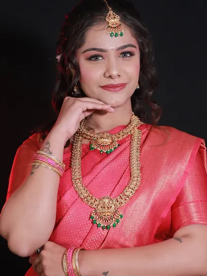 A front view of the student's South Indian bridal makeup. The makeup is clean, the jewelry is perfectly placed, and the model looks radiant.