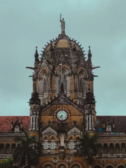 A detailed shot of the clock on the magnificent CSMT building, a masterpiece of Victorian Gothic architecture.