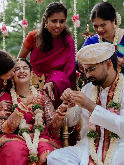The joy of being surrounded by loved ones. This candid moment during a wedding ritual shows the bride's happiness, enveloped by the warmth and support of her family.