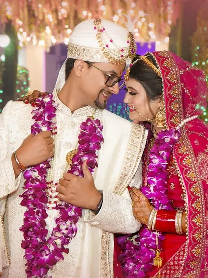 A sweet, intimate moment between the bride and groom during the Varmala ceremony, framed by festive lights.
