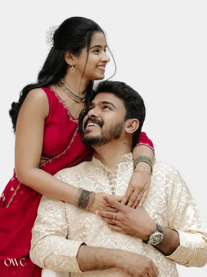 A classic and joyful couple portrait against a clean white background, focusing on their happy expressions.
