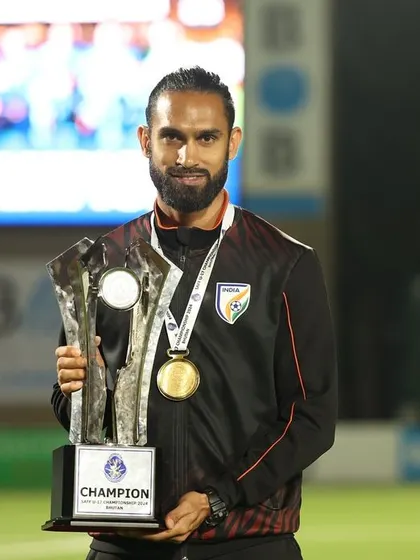 Holding the SAFF U-17 Championship trophy. This represents a significant achievement and is a proud moment for me as part of the coaching staff.