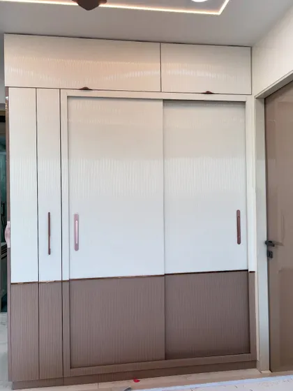 A multi-functional wardrobe unit combining hinged and sliding doors. The mix of white and textured brown laminates adds visual interest.