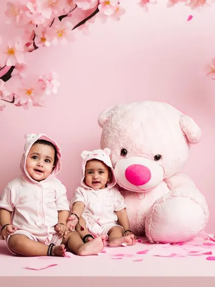 An AI-enhanced version of our twin photoshoot. We placed these adorable babies in a magical pink landscape with cherry blossoms, creating a fantasy portrait.