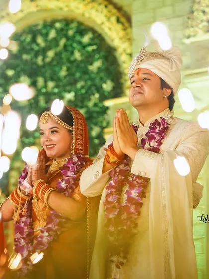 The couple offering a prayer of thanks, framed by celebratory sparklers. This shot combines tradition with a touch of modern celebration for a beautiful effect.