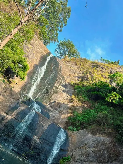A slender waterfall trickles down a rocky cliff in Kodaikanal, showing the delicate side of nature's waterworks.