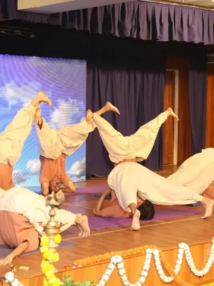 A powerful moment from our students' anniversary performance, showcasing advanced synchronized asanas. These demonstrations are a celebration of what can be achieved through dedicated group practice.