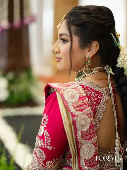 A side profile showing the intricate hairstyle and makeup details for the sister of the bride.