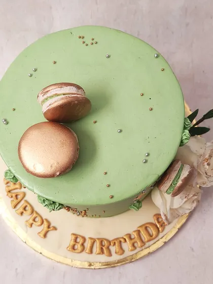 We combine modern elegance and classic flavors in this sage green cake. Adorned with gold leaf, delicate white roses, and gold-dusted macarons, this design is a sophisticated and stylish choice for a special birthday celebration.