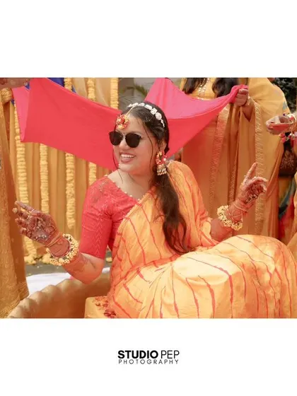 The bride makes a cool entrance, wearing sunglasses and being escorted under a pink canopy held by her bridesmaids.