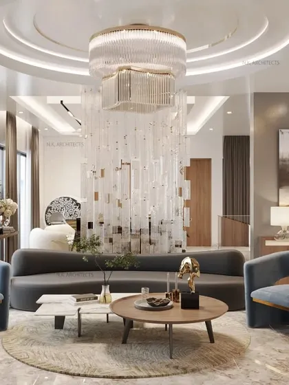 A family lounge designed for comfort and style. The space is defined by a stunning central chandelier that acts as a sculptural partition, with soft, curved furniture in calming blue and grey tones.