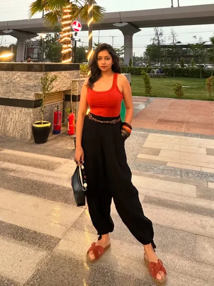 A full-length shot of the orange and black outfit. The relaxed fit of the pants makes it a comfortable yet stylish choice.