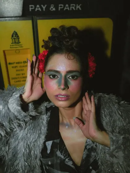 This 'Lampione' shot uses the "Pay & Park" sign as an urban backdrop, grounding the high-fashion look in a real-world environment.