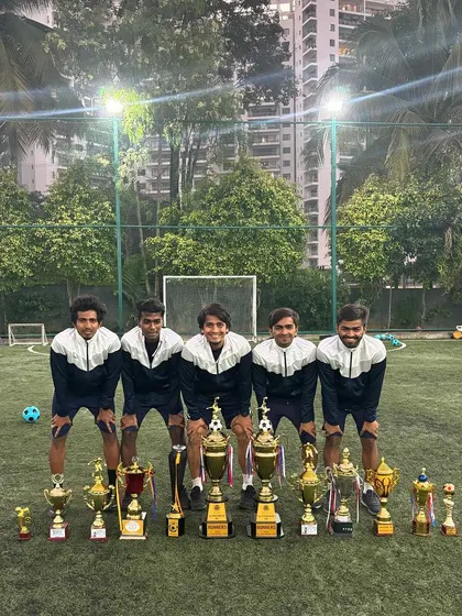 A group of our coaches with the academy's trophy collection. A proud display of our collective achievements.