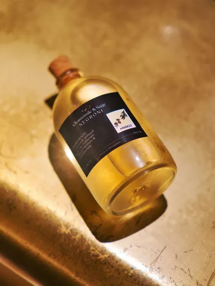 A beautifully lit shot of our Chamomile & Sage Negroni. The golden hue and elegant bottling reflect the sophisticated and delicate nature of this unique white Negroni variation.