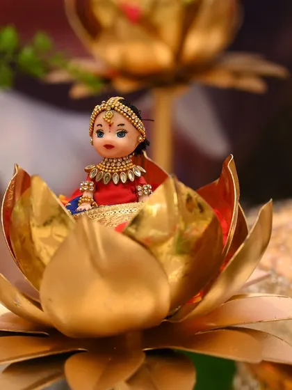 A beautifully detailed doll with traditional jewelry, seated in a brass lotus. These small touches make the decor feel very personal.