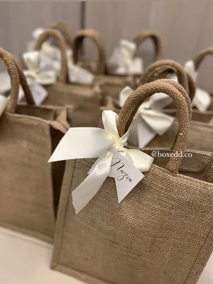 A collection of our personalized jute favor bags. Seeing them together shows how we can create a cohesive look for all your guest gifts, each with a personal name tag.
