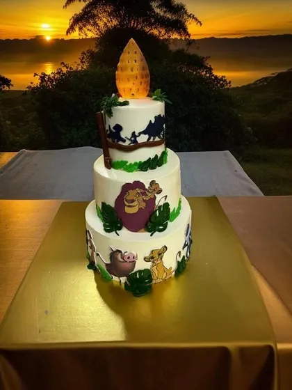 A majestic three-tier Lion King cake set against a beautiful sunset backdrop. Featuring silhouettes and characters from the iconic movie, this cake captures the "Circle of Life" for a truly special celebration.