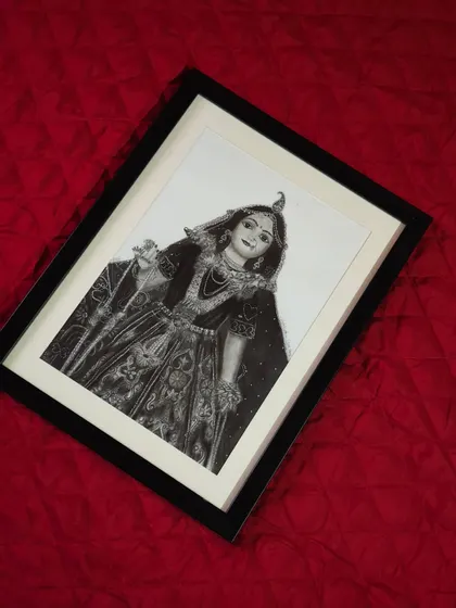 Another angle of the framed Radha Rani portrait, showing how the simple black frame complements the black and white artwork.