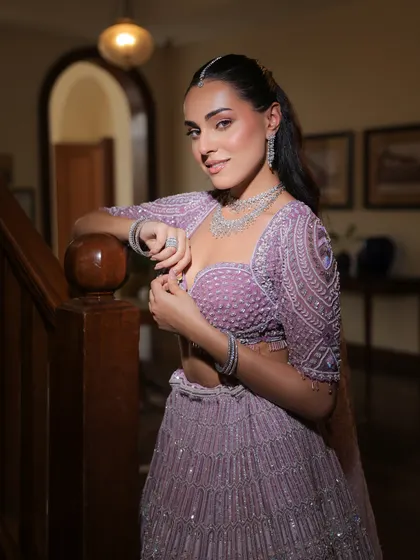 A poised and elegant portrait of the bride on a staircase, her lavender lehenga beautifully cascading down the steps.