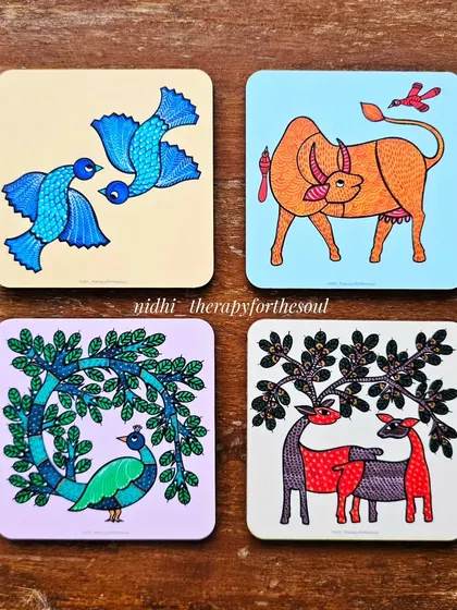A closer look at four of the coaster designs, featuring birds, a cow, a peacock, and deer in the vibrant Gond style.