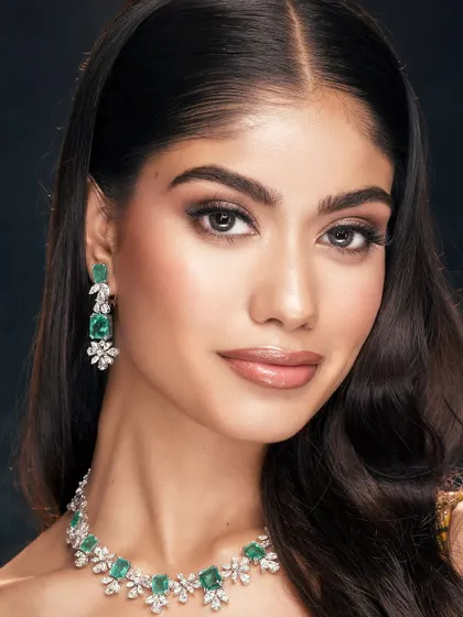 A clean and radiant beauty portrait. The soft makeup enhances the model's natural features, while the emerald and diamond jewelry adds a touch of elegance.