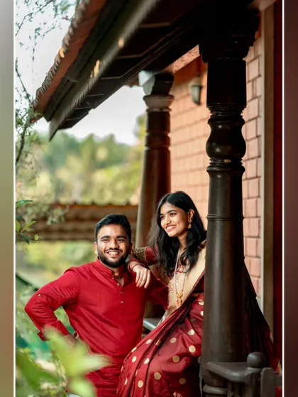 A happy, relaxed portrait of the couple on the porch of a heritage home, showcasing their natural chemistry.