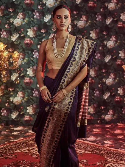A full-length view of our classic navy blue Banarasi saree. The rich gold brocade work on the pallu and border is designed to create a striking and regal silhouette for any formal occasion.