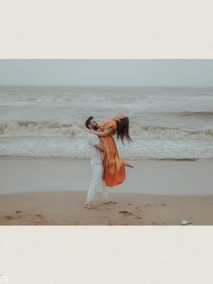A joyful lift against the backdrop of the ocean, capturing a perfect moment of happiness.