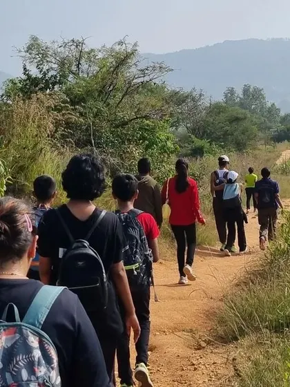 A view from behind of a group walking along a dirt path on their way to the summit.