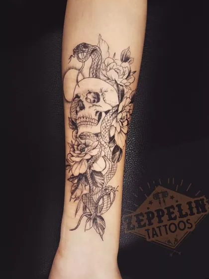 A detailed skull and snake composition. The snake weaving through the skull's eye sockets creates a classic and powerful symbol of death and rebirth.