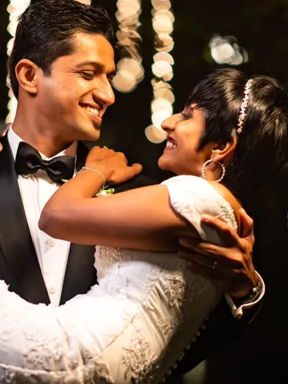 The look of love. A happy couple shares a dance, with the bokeh from the fairy lights creating a magical, dreamy background.