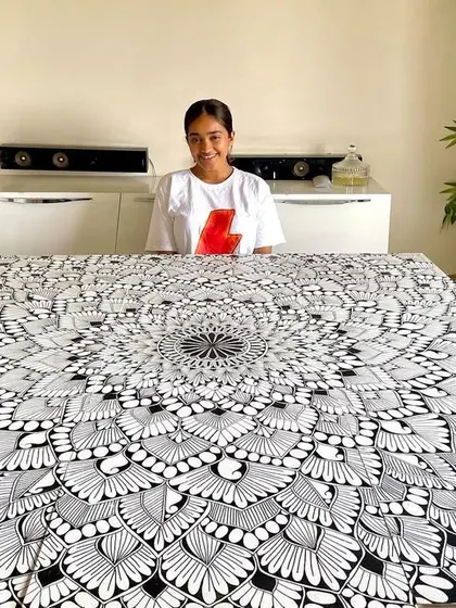 Nothing but big mandala frames. A photo of me with a huge, incredibly detailed black and white mandala canvas.