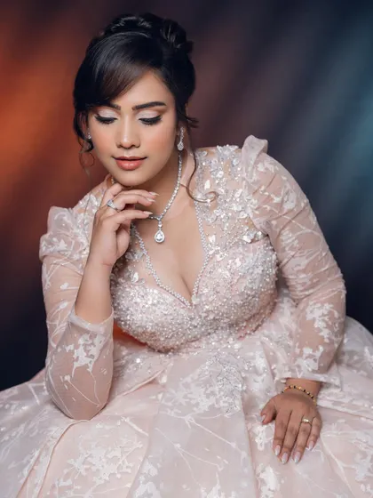 A moment of elegance. The soft lighting highlights the delicate details of her makeup and the intricate embroidery of her gown, creating a truly magical bridal portrait.